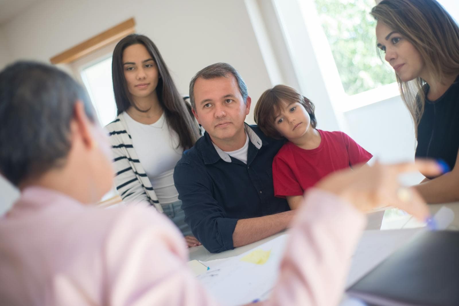 A family meets with a professional advisor at their kitchen table to discuss in-home companion care options.